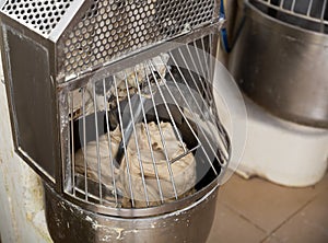 Baker preparing the dough for bread in a dough mixer