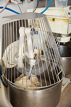 Baker preparing the dough for bread in a dough mixer