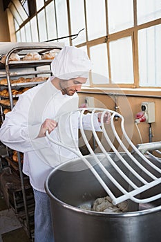 Baker preparing dough in industrial mixer