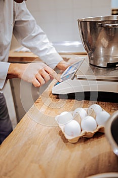 Baker putting bowl with whisked egg whites on kitchen scale photo