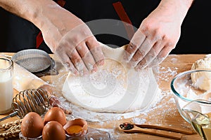 Baker rolling dough with flour bread, pizza or pie recipe ingredients with hands, food on kitchen table background, working with m