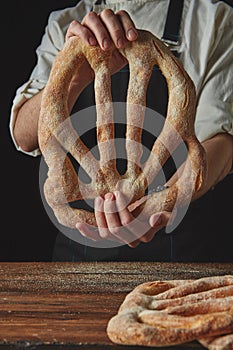 Baker`s hands hold fougas bread