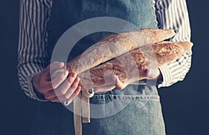 Baker& x27;s hands hold fresh baguettes