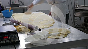 Baker scoring and cutting dough pastry circles in bakery