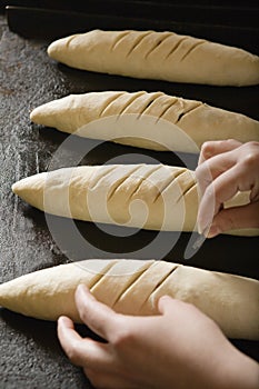 Baker Scoring Loaves Of Bread Dough