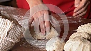 Baker shaping the portioned dough to buns