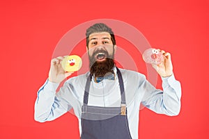 At baker shop. mature man red backdrop. skilled baker with donut dessert. funny hipster cook doughnut. temptation while