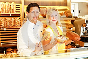 Baker and shopkeeper present pastry