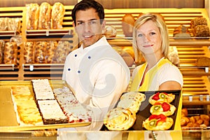 Baker and shopkeeper present pastry