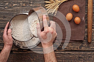 Baker sift the flour to make bread photo