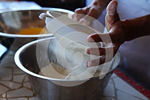 Baker sifting flour for bread