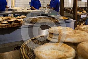 Baker sifting flour through a sieve in bakery shop.