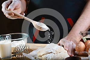 Baker sprinkle the dough with flour bread, pizza or pie recipe ingredients with hands, food on kitchen table background, working w