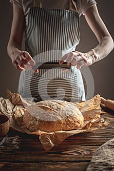 A baker is taking pictures of homemade fresh bread on his phone for a post on social networks. Baking bakery products