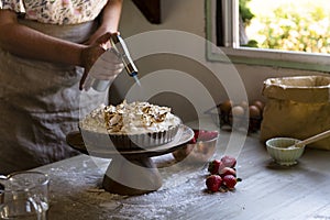 Baker using gas burner on lemon meringue pie photo