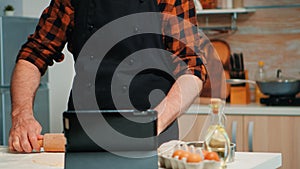 Baker using tablet cooking home cakes