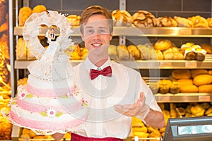 Baker with wedding cake in confectionery