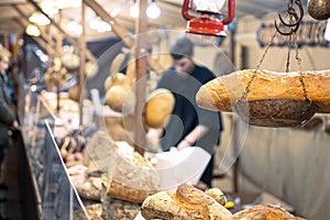 Bakers selling Hogazas, typical Spanish bread loaf, in a bakery stall at traditional market photo