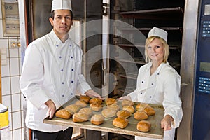 Bakers with tablet of bread in bakery or bakehouse photo