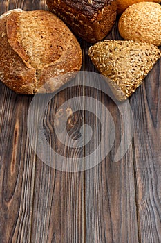 Bakery background, bread assortment on black wooden backdrop. Top view with copy space