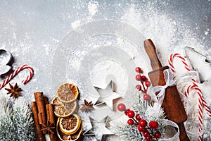 Bakery background for cooking christmas baking with rolling pin, scattered flour and spices decorated with fir tree top view.