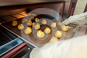 Bakery baker preparing bread cooking in the oven.Bakery close up holding a peel with freshly baked.Activity during quarantine home