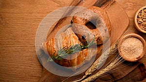Bakery bread background with bagel, croissant on a wooden plate