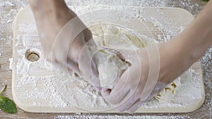 Bakery female worker diligently kneading dough before making bread portion