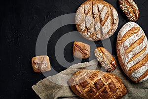 Bakery - gold rustic crusty loaves of bread and buns on black chalkboard background.