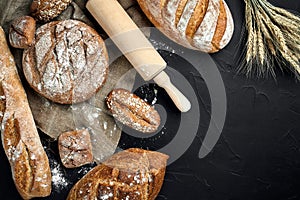 Bakery - gold rustic crusty loaves of bread and buns on black chalkboard background.