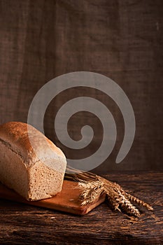 Bakery - gold rustic crusty loaves of bread and buns on black chalkboard background. Still life captured from above