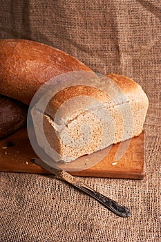 Bakery - gold rustic crusty loaves of bread and buns on black chalkboard background. Still life captured from above