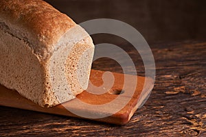 Bakery - gold rustic crusty loaves of bread and buns on black chalkboard background. Still life captured from above