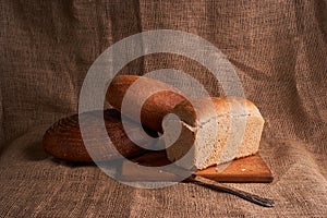 Bakery - gold rustic crusty loaves of bread and buns on black chalkboard background. Still life captured from above