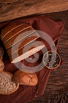 Bakery - gold rustic crusty loaves of bread and buns on black chalkboard background. Still life captured from above