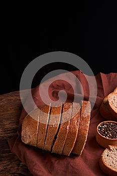 Bakery - gold rustic crusty loaves of bread and buns on black chalkboard background. Still life captured from above