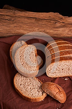 Bakery - gold rustic crusty loaves of bread and buns on black chalkboard background. Still life captured from above