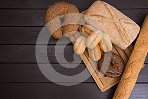 Bakery - gold rustic crusty loaves of bread and buns on black chalkboard background top view