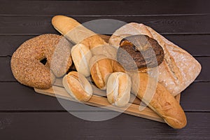 Bakery - gold rustic crusty loaves of bread and buns on black chalkboard background top view