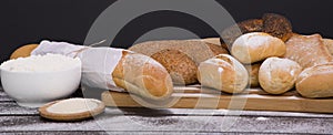 Bakery - gold rustic crusty loaves of bread and buns on black chalkboard background top view