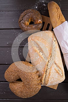 Bakery - gold rustic crusty loaves of bread and buns on black chalkboard background top view