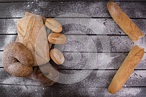 Bakery - gold rustic crusty loaves of bread and buns on black chalkboard background top view