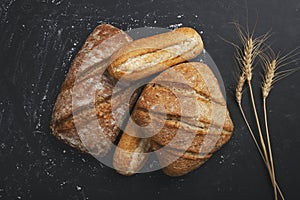 Bakery - gold rustic loaves of bread and flour on black chalkboard background.