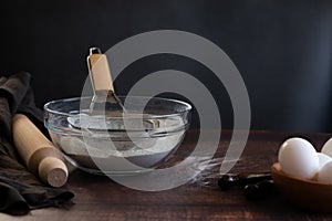 Bakery items - flour and eggs on dark background, healthy basic baking ingredients