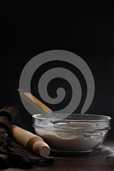 Bakery items - flour and eggs on dark background, healthy basic baking ingredients