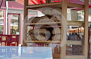 A bakery market stall with homemade loaves of breads arranged in the shelves on Saturday market in Freiburg im Breisgau on Cathedr