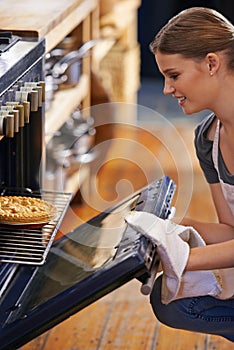 Bakery, oven and woman with a pie in kitchen and cooking as a chef at restaurant or cafe. Person, smile and baker