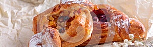 Bakery products on baking paper on wooden table.