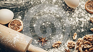 Bakery products. Cooking food ingredients: flour, eggs, nut and star anise, orange on dark table kitchen background for cake.