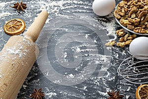 Bakery products. Cooking food ingredients: flour, eggs, nut and star anise, orange on dark table kitchen background for cake.